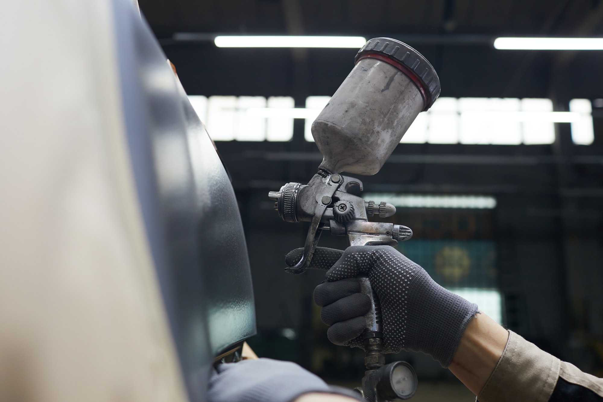 Hand With Spray-gun Painting Car