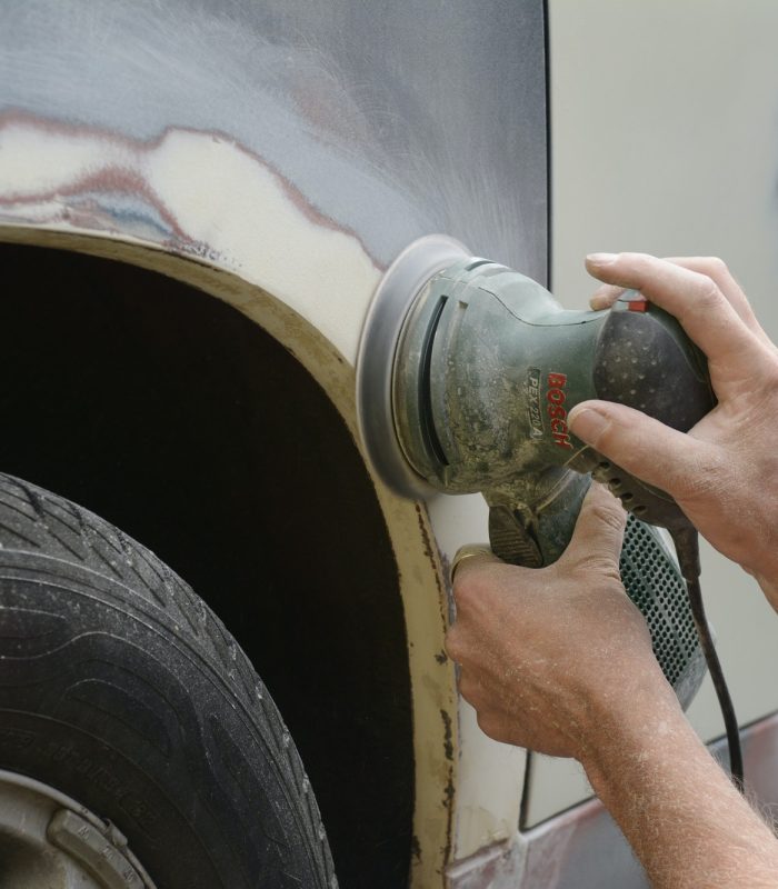 Germany, Zeuthen, Man mending car paint