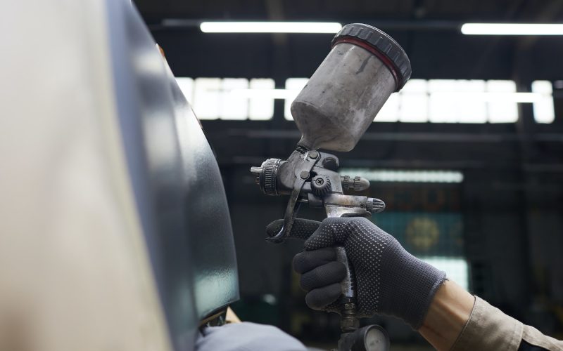 Hand With Spray-gun Painting Car