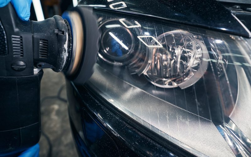 Headlight polishing with orbital sander on repair shop