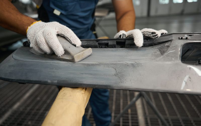 Male stripping paint before painting car detail