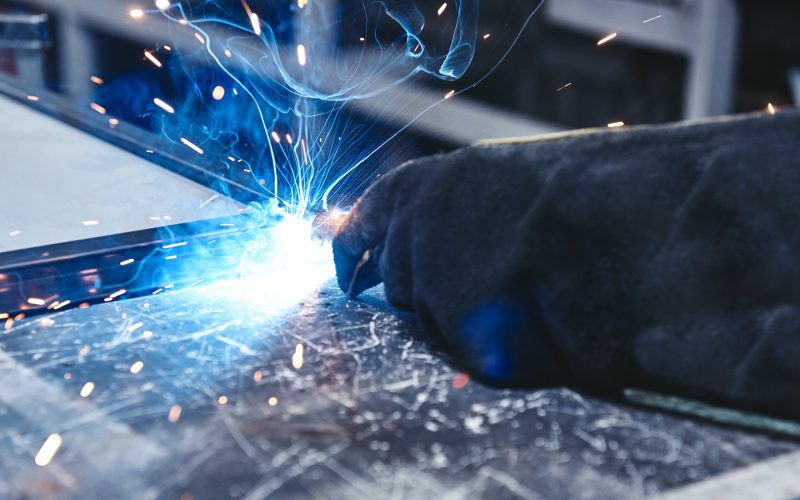 The better way to weld. Hand in glove hold welding steel. Welds with argon-arc welding